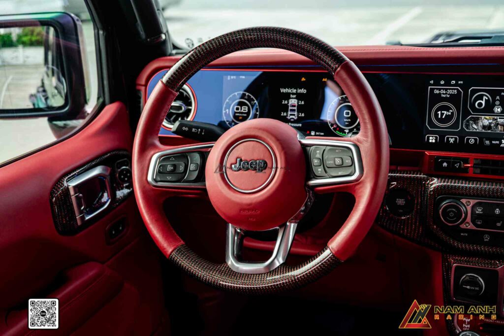 Vô lăng bọc da đỏ đồng bộ với tổng thể nội thất, tạo liên kết màu sắc liền mạch.

