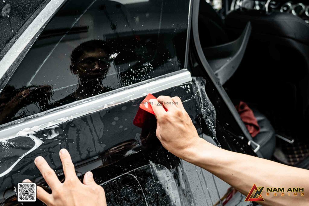 Nam Anh Racing áp dụng kỹ thuật gán phim PPF công nghệ cao, cho phép điều chỉnh lực gạt và hướng film theo từng góc cạnh thân xe