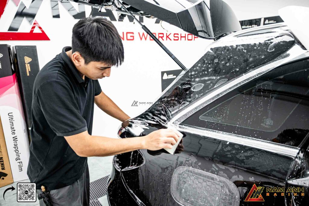 Kỹ thuật viên tinh chỉnh chi tiết lớp PPF để đạt bề mặt hoàn hảo cho thân xe.